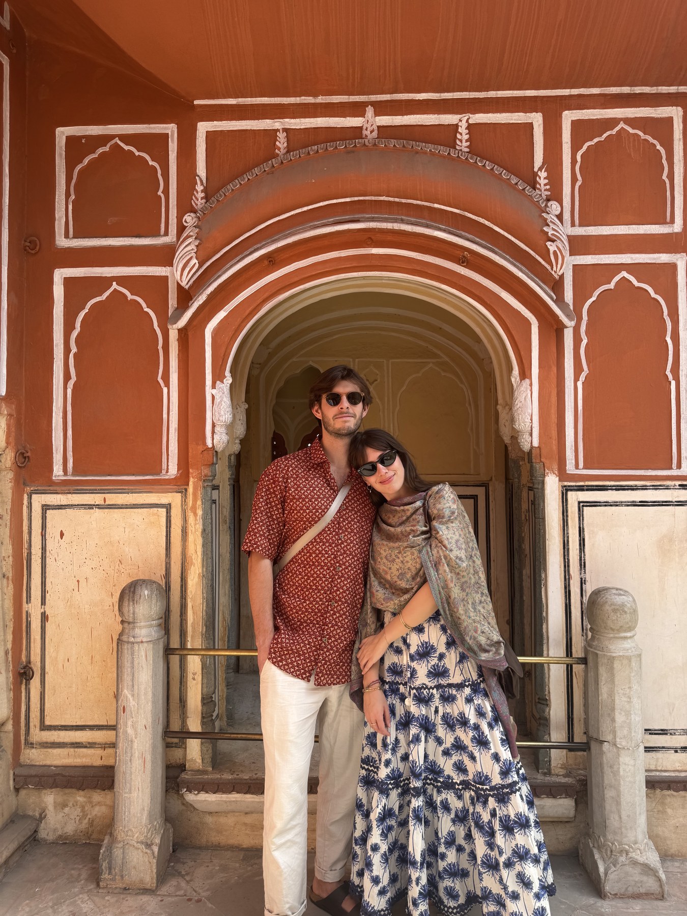 Giuliana and Arthur standing beneath an ornate arch in India